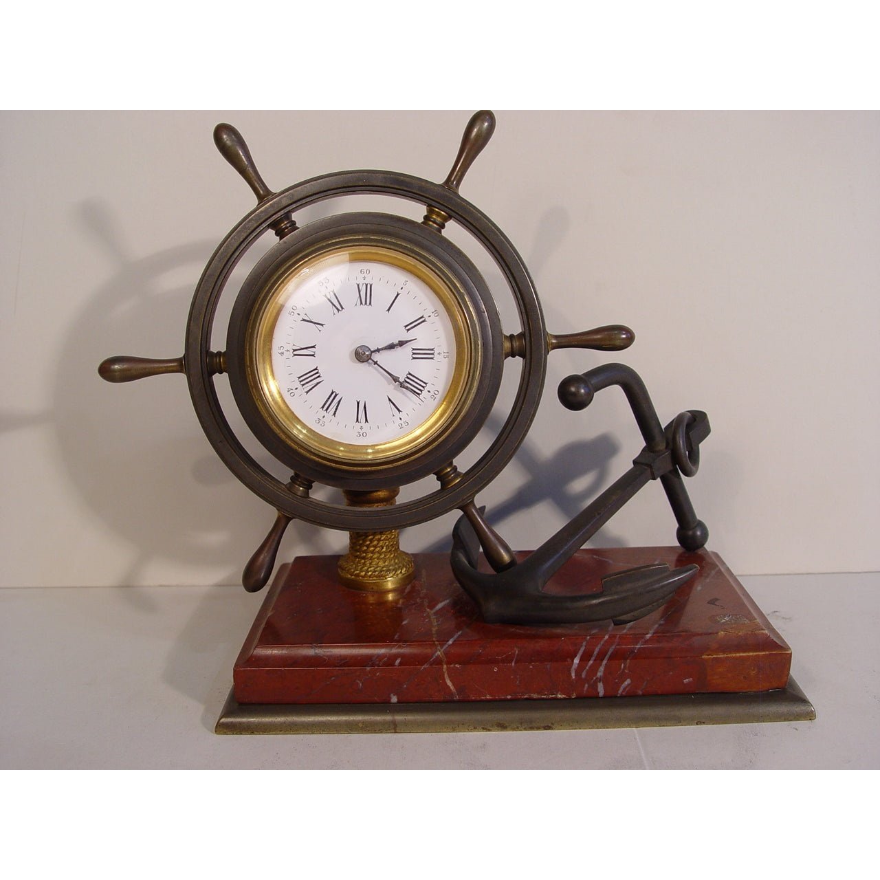 A French Late 19th Century Industrial Ships Wheel Timepiece Clock, the  rouge marble base supporting a bronze ships wheel and anchor, the French  late 19th century 8-day timepiece movement with a platform
